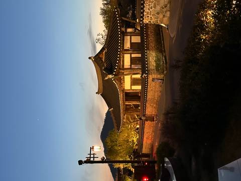       Traditional Korean hanok house softly illuminated at dusk against a fading blue sky.
  