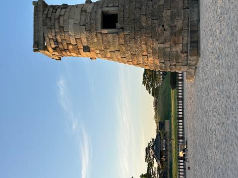       Stone Cheomseongdae observatory bathed in golden hour light against a pastel sky.
  
