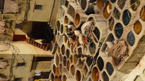       Traditional leather tannery with circular dye pits and workers at Fes
  