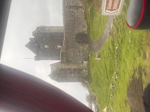       Castle photographed through rain-speckled bus window on a gray day.
  