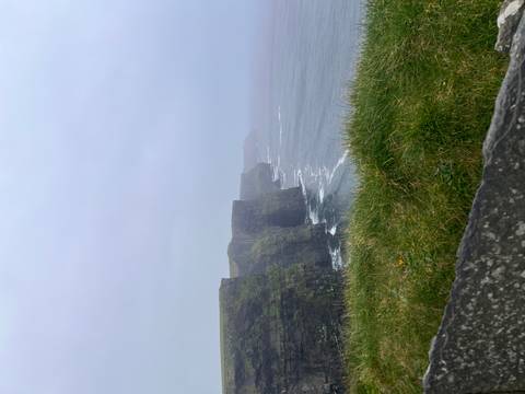       Misty cliffs drop to crashing Atlantic waves along the Cliffs of Moher.
  
