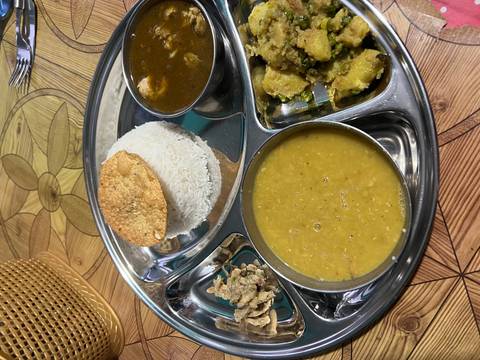       Traditional Nepali dal bhat meal served on a compartmental metal tray with rice, lentils and curries.
  