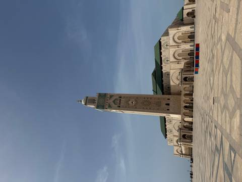       Majestic Hassan II Mosque rises over a vast marble courtyard beneath a hazy sky in Casablanca
  