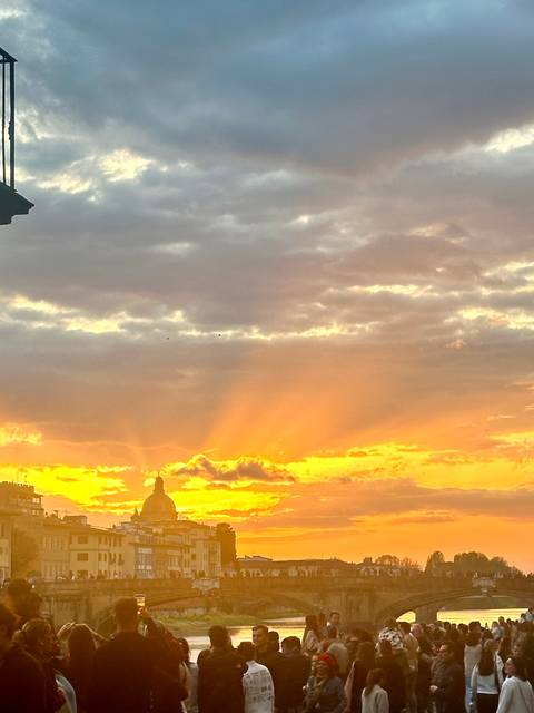       Dramatic golden rays burst through clouds over a silhouetted city skyline at sunset
  