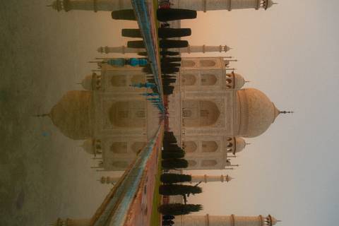       The Taj Mahal glows softly at dawn, perfectly mirrored in the long reflecting pool leading to the mausoleum.
  