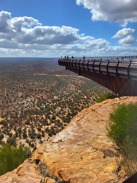       Kalbarri Skywalk juts over a vast rugged gorge while visitors admire the view.
  