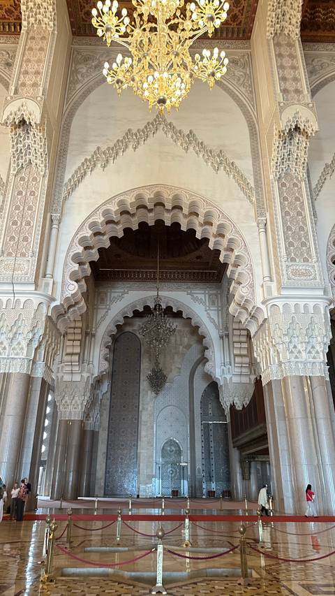       Intricate arches and chandelier of the ornately carved Hassan II Mosque interior
  