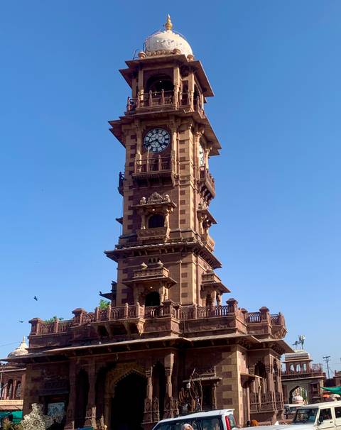       Historic sandstone clock tower rises into clear blue sky in Jodhpur
  