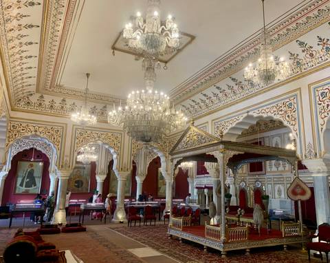       Lavish palace interior with chandeliers, painted ceilings and gold throne
  