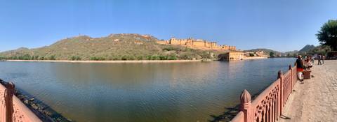       Hilltop fort complex overlooking a calm lake and surrounding arid hills under clear blue sky.
  