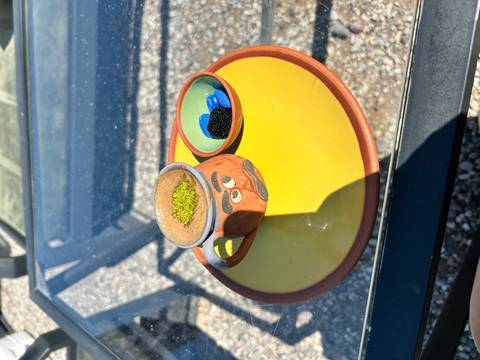      Cup of traditional Turkish coffee with pistachio dust on a colourful plate.
  
