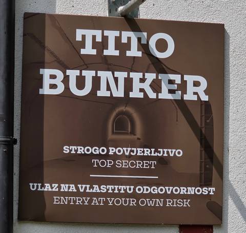       Informational sign reading 'Tito's Bunker – Top Secret' on a wall
  
