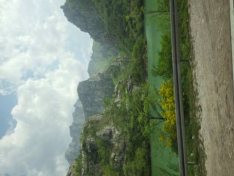       Mountain lake valley viewed from roadside with guardrail in foreground
  