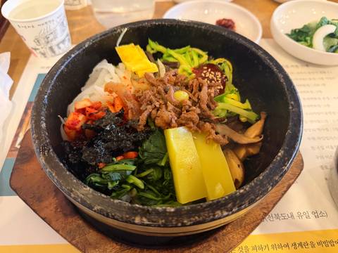       Korean bibimbap bowl filled with vibrant vegetables, rice and beef.
  