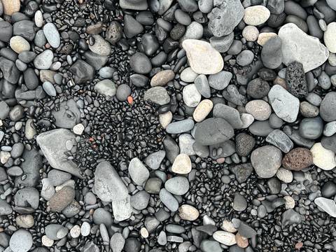       Close-up of smooth black and grey volcanic pebbles on Iceland’s south coast.
  