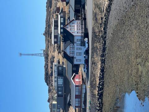       Quiet Icelandic seaside village with colourful houses set on a rocky shore.
  