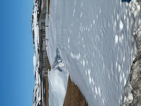       Snow-covered farm field with fences under a clear blue sky in Icelandic highlands.
  