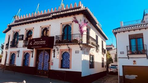       Traditional Andalusian building with ornate iron balconies and sign for flamenco tablao
  