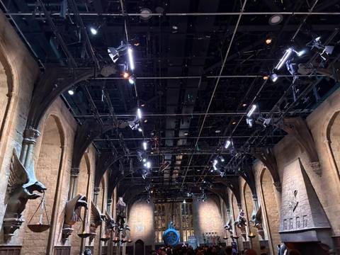       Upward view of dark ceiling grid packed with spotlights in a large hall
  