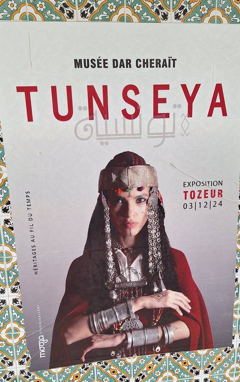       Poster advertising a cultural exhibition featuring a traditionally dressed woman.
  