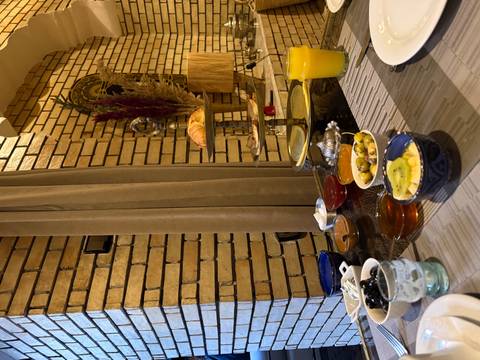       A Moroccan breakfast spread with olives, jams and juice is set against a rustic brick interior
  