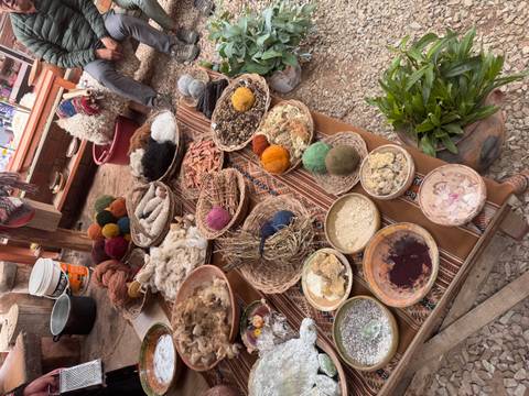       Display table of natural dyes, yarns and Andean weaving materials in an artisan workshop.
  