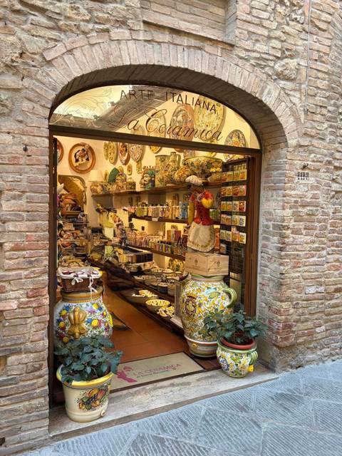       Charming shop doorway stocked with colourful hand-painted ceramics and Tuscan souvenirs.
  