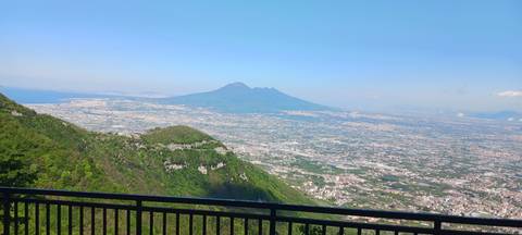       Panoramic viewpoint overlooking sprawling plains with Mount Vesuvius dominating the horizon.
  