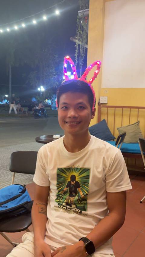      Portrait of a smiling young man in a casual café at night.
  