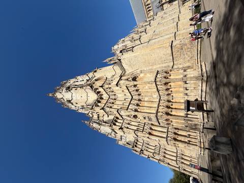       Dramatic upward view of York Minster’s soaring Gothic tower under a deep blue sky.
  