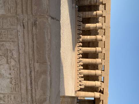       Ram-headed sphinx colonnade and massive pillars inside an Egyptian temple.
  