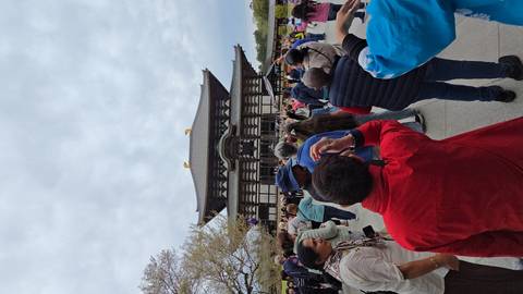       Large crowd gathers in front of the wooden Great Buddha Hall of Todaiji Temple on an overcast day.
  