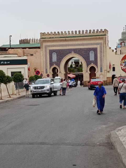       Traffic and pedestrians pass through the ornate blue-tiled Bab Bou Jeloud gate in Fes.
  