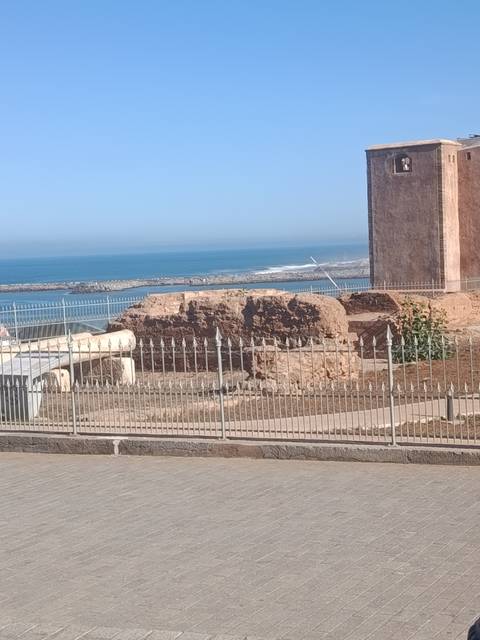       Stone ruins overlooking a rocky Atlantic shoreline under a clear blue sky.
  