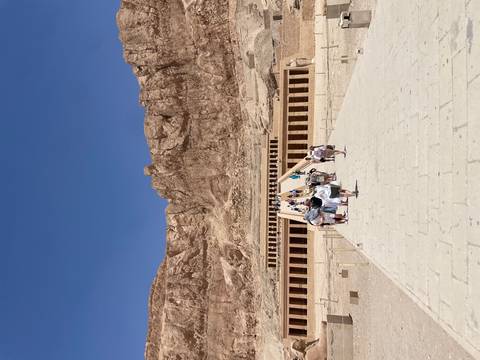       Visitors walk up the long causeway to Hatshepsut’s terraced mortuary temple set against sheer cliffs.
  