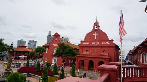       The red Dutch-era Christ Church and Malaysian flag dominate the historic square in Melaka.
  