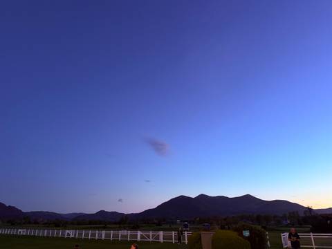       Subtle dusk gradient sky over distant mountain silhouettes and valleys.
  
