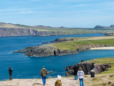       Sweeping coastal cliffs and turquoise sea at Slea Head with visitors admiring the view.
  