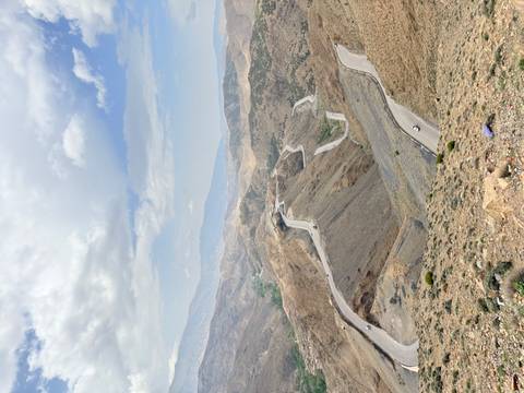       Aerial view of winding mountain road snaking through barren Atlas slopes.
  
