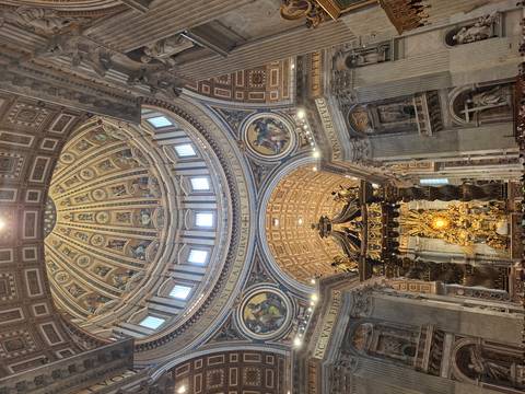       Ornate interior of St Peter's Basilica featuring the grand baldachin and gilded dome
  