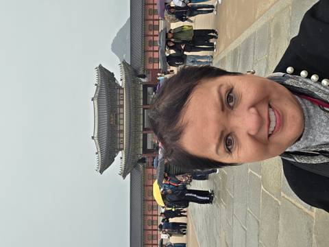       Selfie with Gyeongbokgung Palace gate and visitors holding umbrellas in the rain.
  