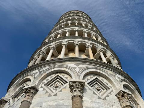       Dramatic worm's-eye view of the Leaning Tower of Pisa against a deep blue sky.
  