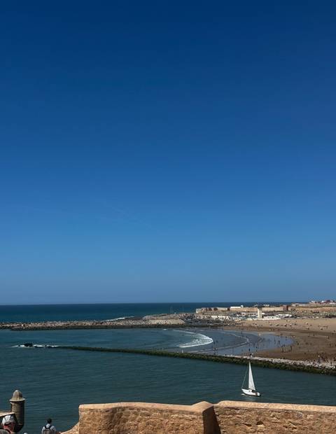      A vast expanse of clear blue sky meets a distant horizon over the sea.
  