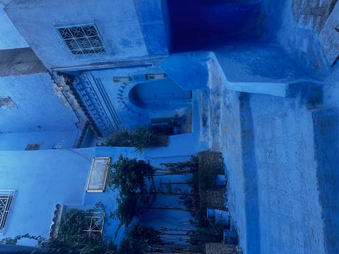       Quiet blue-washed courtyard and arched doorway in Chefchaouen’s old town.
  