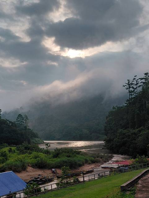       Misty clouds rolling over dense tropical rainforest and distant hills.
  