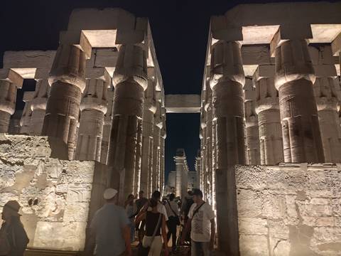       Night visit to Luxor Temple’s grand colonnade lit dramatically with tourists walking between the pillars.
  