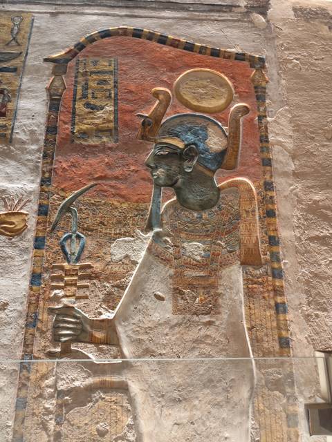       Detailed painted relief of an Egyptian pharaoh with vibrant colors and intricate patterns.
  