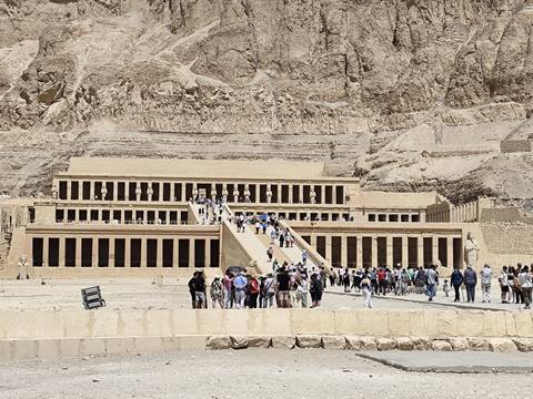       Crowds ascending the terraces of Hatshepsut’s mortuary temple set against rugged desert cliffs.
  