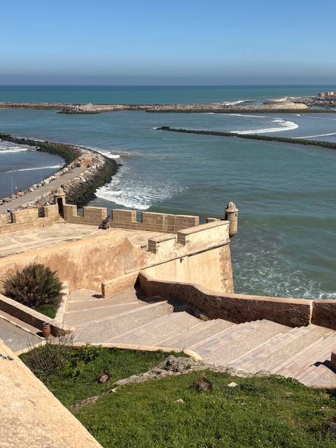       Stone ramparts and bastion overlooking turquoise ocean waves at a historic coastal fort
  