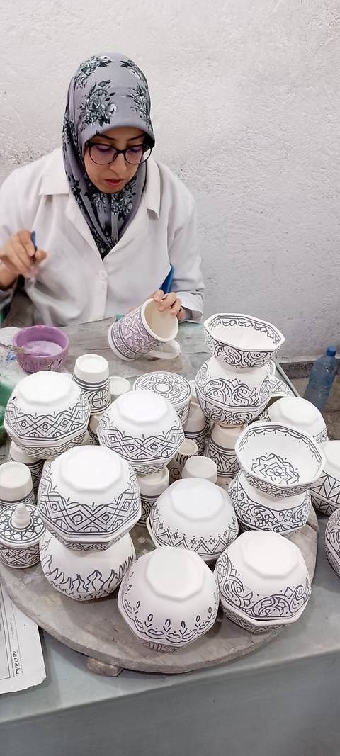       Artisan painting intricate geometric designs on ceramic bowls
  